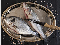 Écailler un poisson avec un couteau